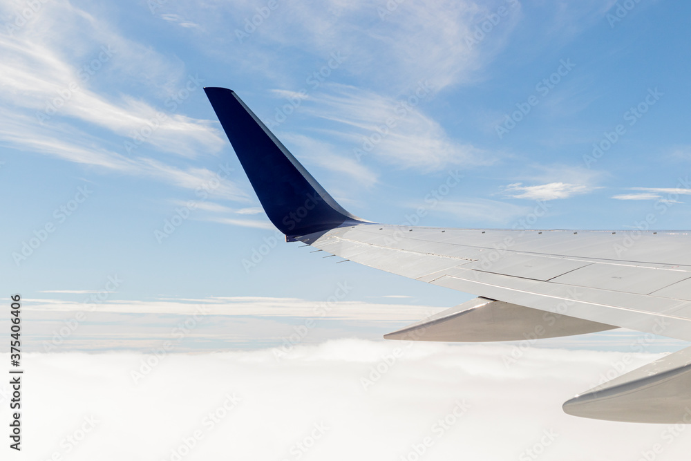 Fototapeta premium View of airplane wing with blue sky in the background