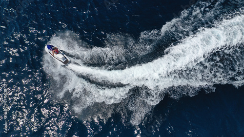 Aerial photo of woman operating jet ski cruising in low speed in deep blue crystal clear waters