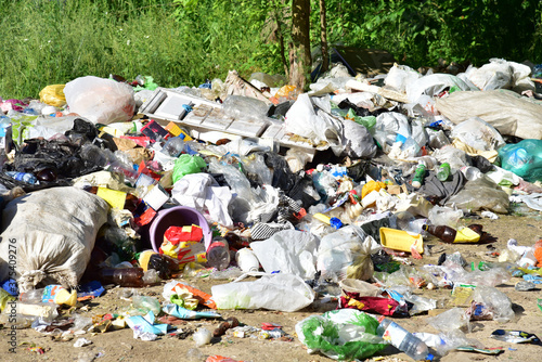 A large number of accumulated plastic bags and plastic packaging of household waste in garbage containers. The problem of garbage removal from the village, the concept of environmental pollution