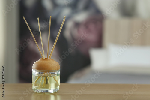 Aromatic reed air freshener on table indoors. Space for text