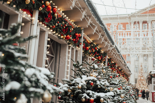 Obraz na płótnie Premises with decorated glowing Christmas trees and bright outdoor decorations. Christmas and New Year holidays. w salonie