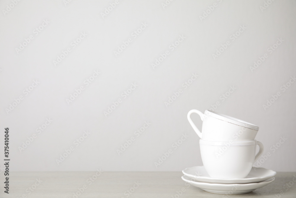 Ceramic saucers and cups on table against white background. Space for text Ceramic saucers and cups on table against white background. Space for text