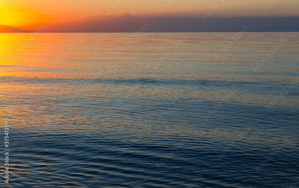 Obraz premium Dawn of the sun at sea. The rising sun behind the mountains. Kyrgyzstan.