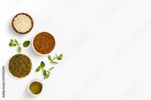 Middle Eastern red and green zaatar spices with fresh zaatar leaves and olive oil. Top view with copy space