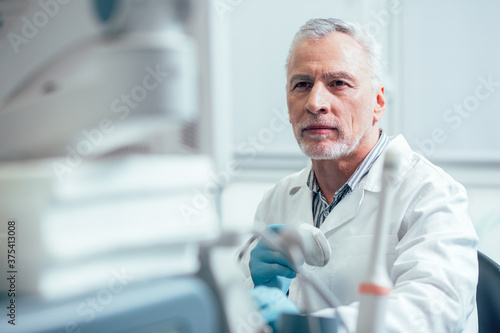 Thoughtful glance of professional male sonographer at work photo