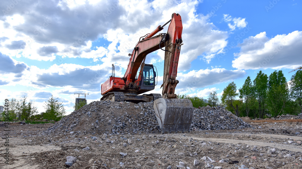 Naklejka premium Excavator work at landfill with concrete demolition waste. Salvaging and recycling building and construction materials. Industrial waste treatment plant. Reuse concrete for new construction