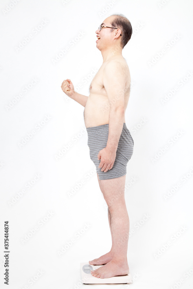 体重計に乗る中年男性