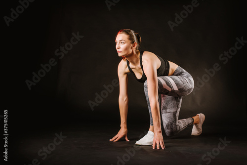 Sport woman doing fitness exercices on black background