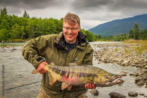 Φωτογραφία A happy sport fisherman holding up a big trophy Chum Salmon