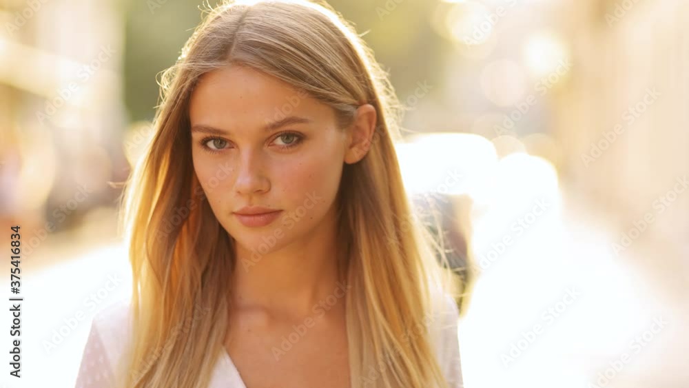 Closeup face of beautiful blond sexy smiling woman with long hair. Portrait of gorgeous girl looking to camera