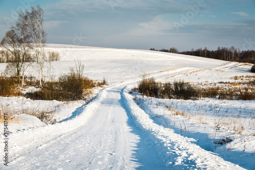 Winter road through snowy fields and forests © Raimonds Kalva