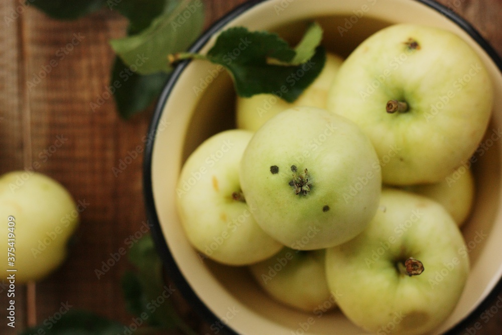 Delicious green apples with leaves on the table