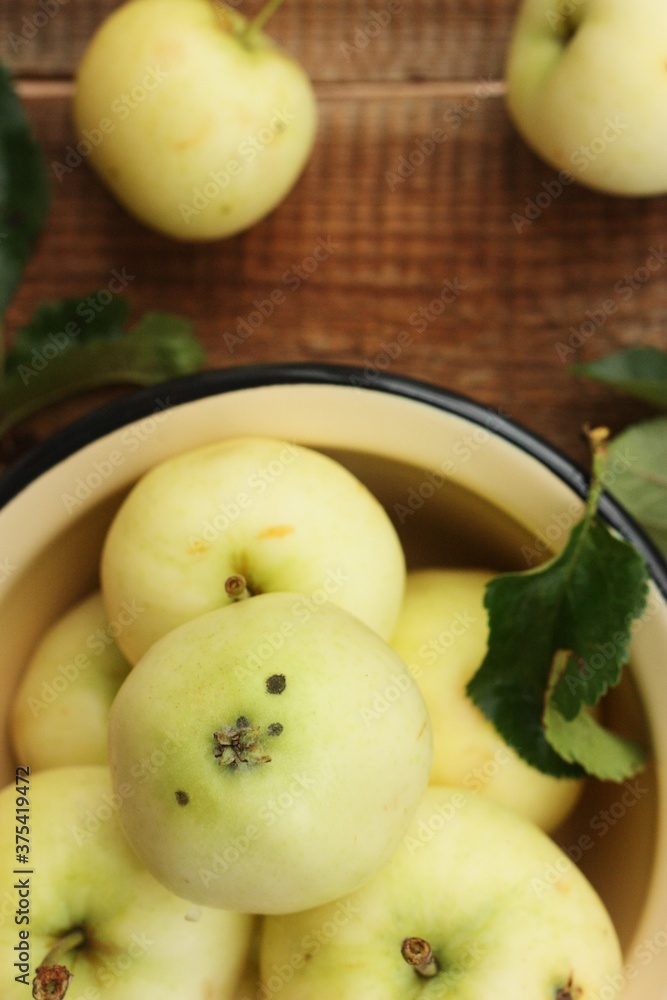 Delicious green apples with leaves on the table