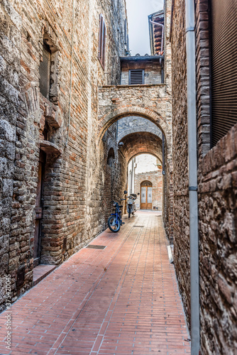 Narrow medieval street with motorcycles in San Gimignano  Italy