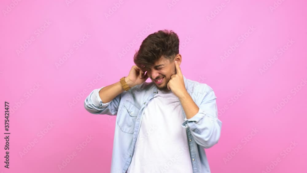 Young arab man covering ears with hands, angry and tired of hearing some sound Young arab man covering ears with hands, angry and tired of hearing some sound