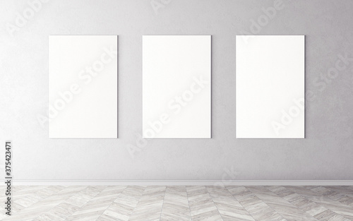 Three white empty canvases on wall. Mockup for you design preview. Good use for advertising materials.