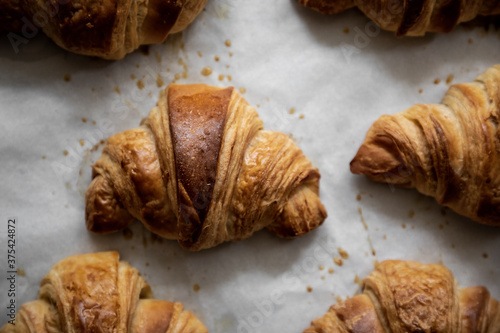 Baked butter croissants on a baking tray close - up