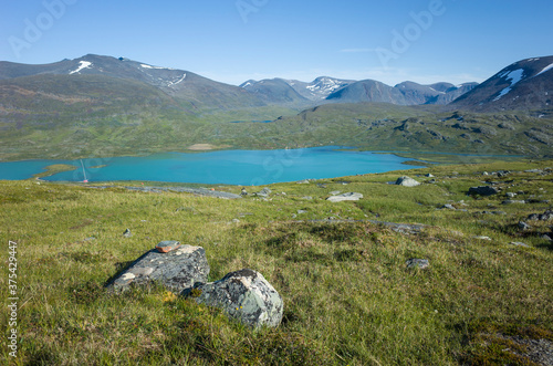 Swedish Lapland landscape. Arctic environment of Scandinavia in warm summer sunny day with blue sky. Lake Alisjavri on Kungsleden and Nordkalottruta Arctic hiking Trail in northern Sweden photo