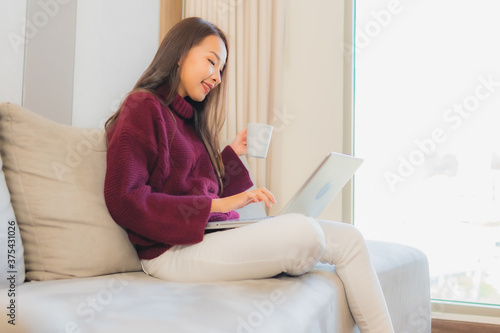 Portrait beautiful young asian woman use computer laptop on sofa