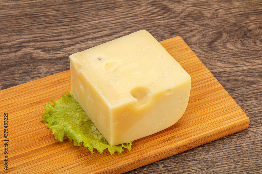 Emmental cheese over wooden board Emmental cheese over wooden board