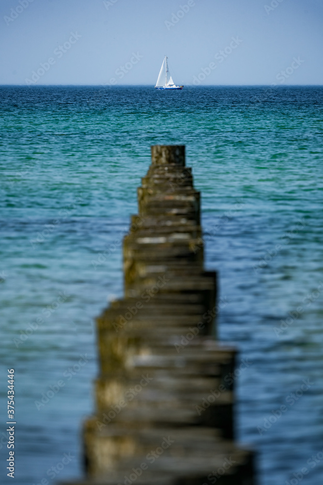 sailboat on the sea at the end of the pier sailboat on the sea at the end of the pier