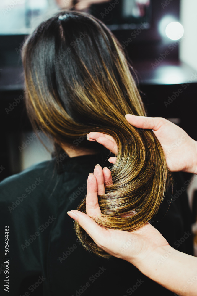 Fototapeta premium Hair stylist showing finished work on hair