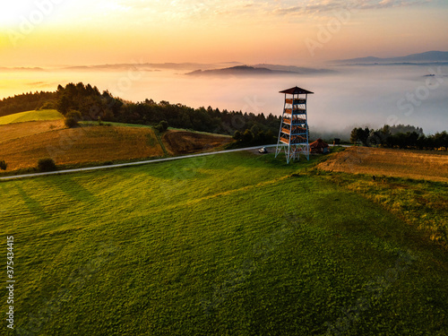 Fototapeta Naklejka Na Ścianę i Meble -  Lookout Tower in Brusnik,Poland and Stunning Countryside at Sunrise in Fog