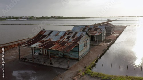 Flight backwards in the salt mine in Bani, Peravia Province, at dusk with a view of a blue car at the end of the clip photo