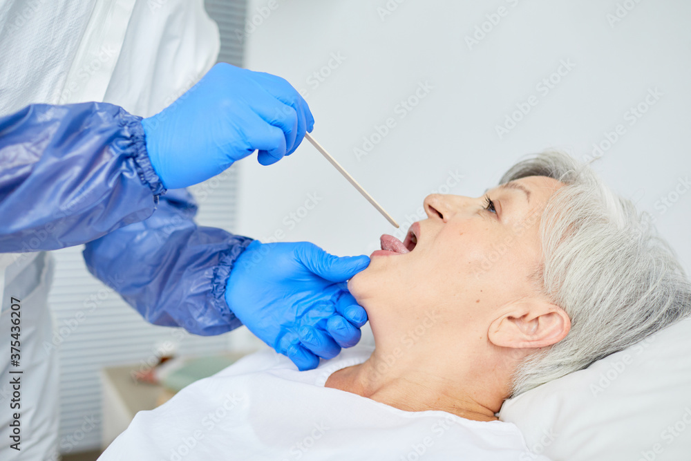 Side view close-up shot of general practitioner waring latex gloves examining senior patient's throat Side view close-up shot of general practitioner waring latex gloves examining senior patient's throat