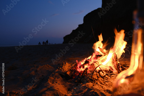 Campfire on the Empty Beach with Girl Silhouette Background