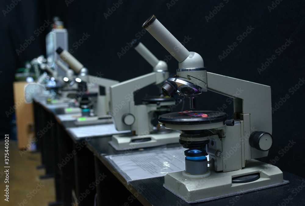 Microscopes set on the worktable of the school lab Microscopes set on the worktable of the school lab