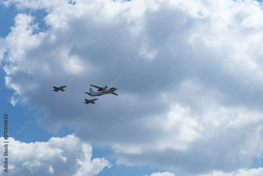 Daylight. large aircraft accompanied by combat vehicles. blue sky Daylight. large aircraft accompanied by combat vehicles. blue sky