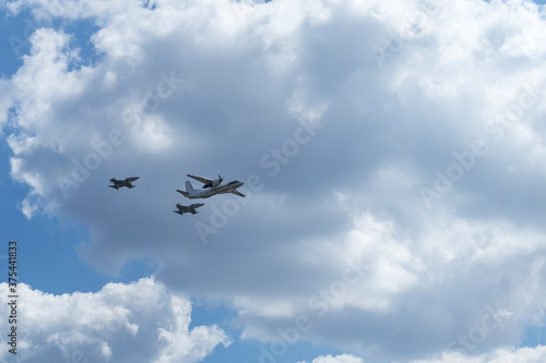 Daylight. large aircraft accompanied by combat vehicles. blue sky