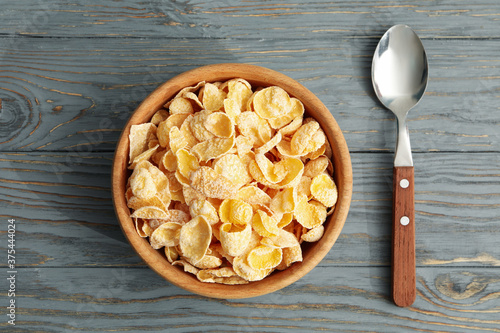 Spoon and bowl of muesli on wooden background