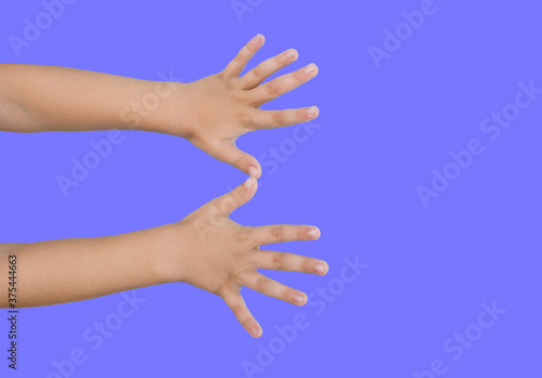 Children's hands are raised up. Isolated on a blue background. Copy of space