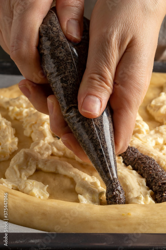 Preparation of Chodsky kolac - creating a pattern using ground poppy seeds and curd photo