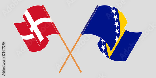 Crossed and waving flags of Denmark and Bosnia and Herzegovina