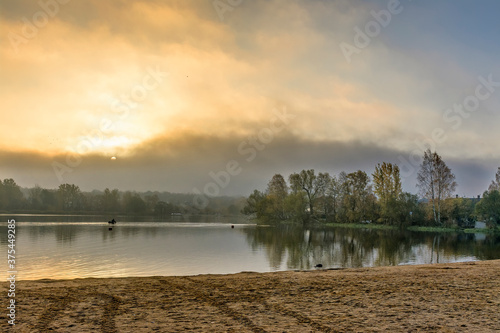 Foggy morning on the beach located on the shore lake.