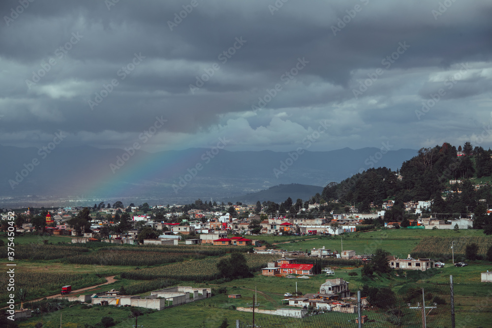 Mexico country landscape, a rainbow appearing on the horizon in front of a hill