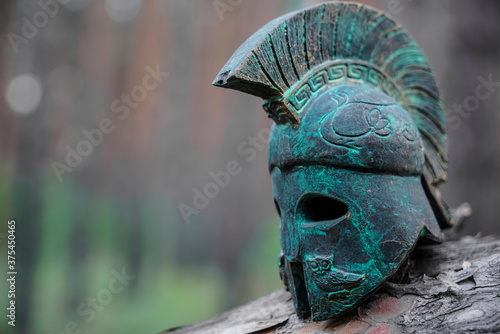 Historical Replica Spartan Warrior Helmet on pine forest background Fototapet