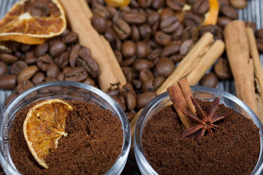 Coffee beans. Ground coffee in containers and spices. On a surface of brushed pine boards painted black and white. Coffee beans. Ground coffee in containers and spices. On a surface of brushed pine boards painted black and white.