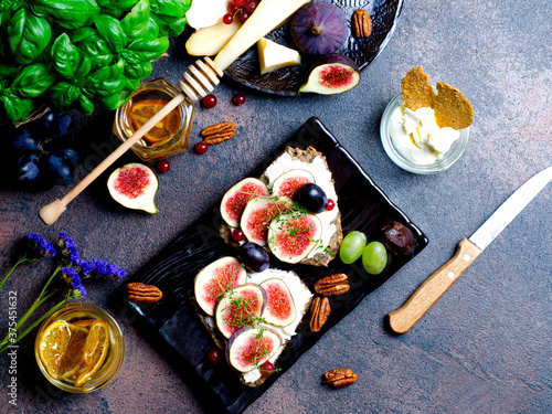 Sandwich with mascarpone cheese and fresh fig fruit, closeup on dark plate