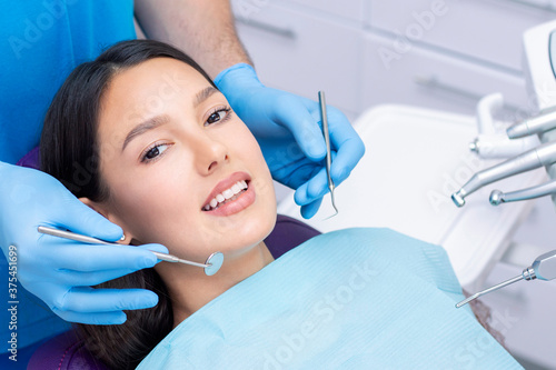 Attractive young woman in a dental clinic with a male dentist. Healthy teeth concept.