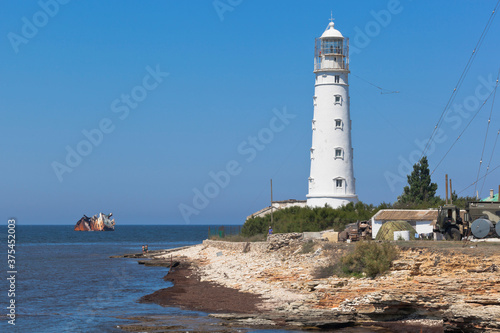 Tarkhankut lighthouse and remains of a Cambodian dry cargo ship stranded by a storm, Crimea