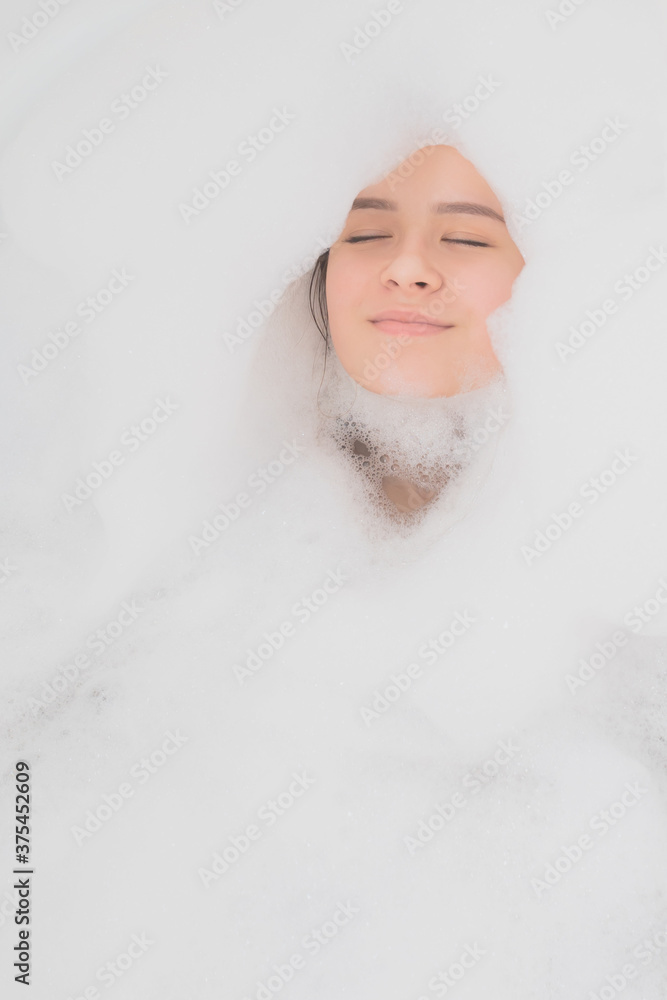 Beauty, spa, personal care. Young woman relaxes in the bath with foam Beauty, spa, personal care. Young woman relaxes in the bath with foam