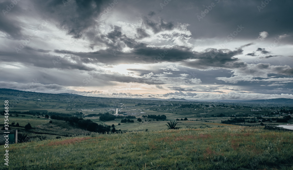 Sunset landscape with rain clouds over the Mexican countryside and a town called Almoloya de Juaréz