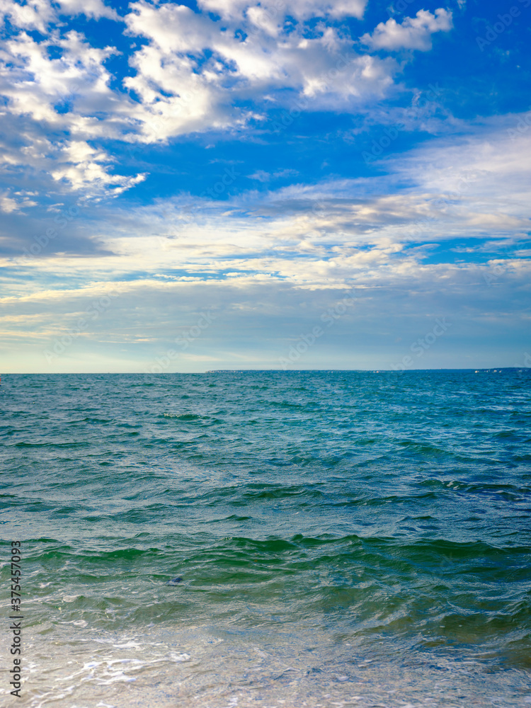 Tranquil seascape with cumulus clouds over the waves in the ocean