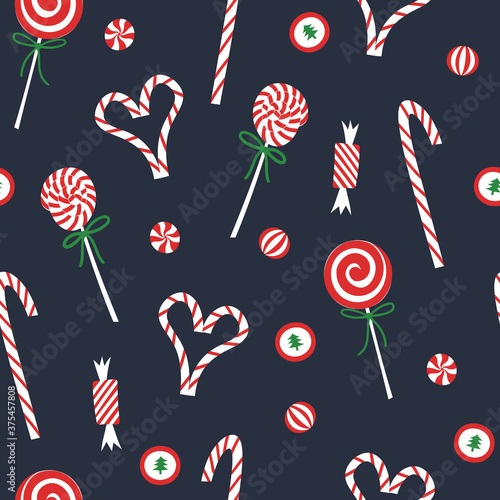 Christmas candy seamless pattern. 
Flat red and white sweet cane, lollipop, bonbons on blue background. Festive xmas and new year print for wrapping or wallpaper.
