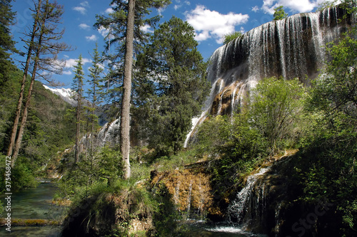 Juizhaigou (Nine Villages Valley) in Sichuan, China. View of Pearl Shoal Waterfall. Juizhaigou is a popular tourist destination in China famous for its waterfalls, lakes and scenic beauty. photo