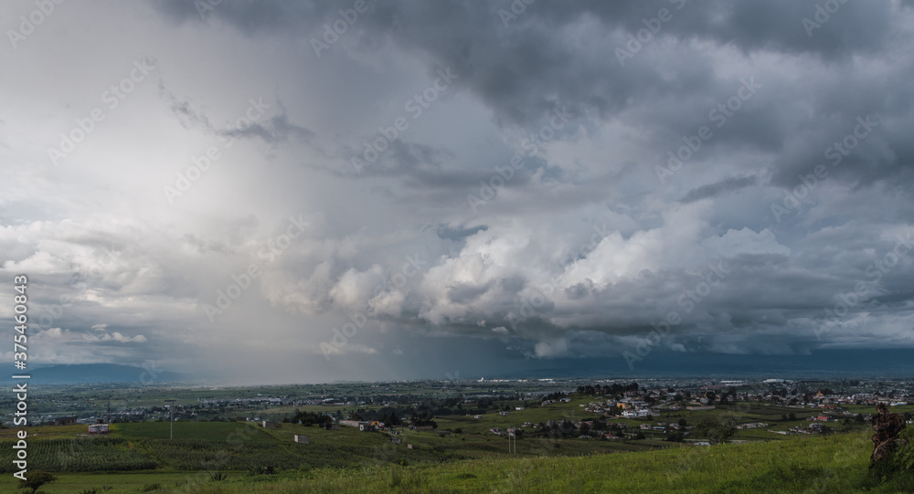 Landscape of rain over the valley, huge clouds take over the place while a storm hits a part of the town